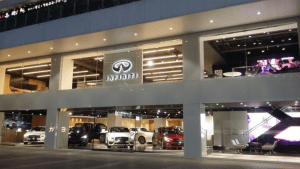 Exterior view of an Infiniti car dealership at night with cars displayed.