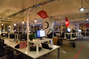 Modern office workspace with computers and hanging lights.
