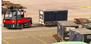 Airport ground vehicle towing a cargo container on the tarmac.