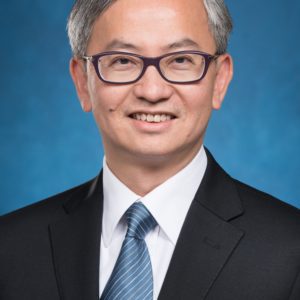 Professional man in suit and tie with glasses smiling.