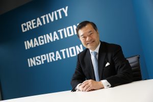 Businessman sitting confidently in front of a motivational wall.