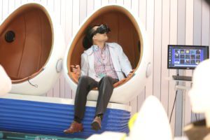 Person wearing VR headset sitting in a modern pod chair.
