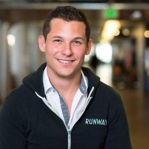 Smiling man in a casual jacket indoors.