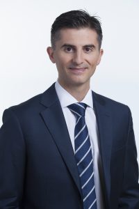 Professional man in a suit with a striped tie, smiling confidently.
