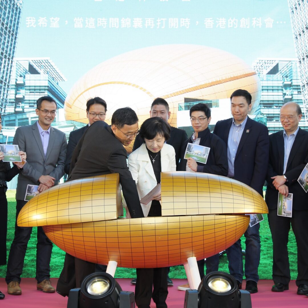 Group of people unveiling a large golden corn sculpture at an event.