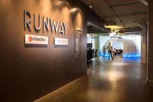 Modern co-working space with a sign for Runway and Gilsocket.