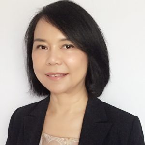 Professional woman with short black hair and a blazer smiling.