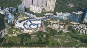 Aerial view of a modern urban park with unique circular buildings and greenery.
