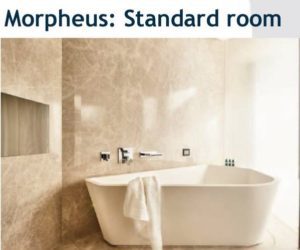 Modern bathroom with a freestanding bathtub and beige marble walls.