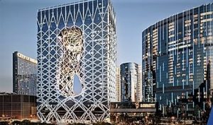 Modern buildings with artistic facade and reflective glass in an urban setting.