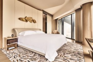 Modern bedroom with large windows and artistic decor.