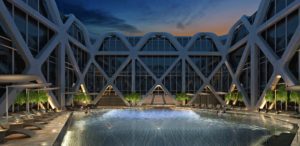 Modern geometric building with a pool at dusk under a colorful sky.