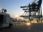 Cargo cranes and a truck at a shipping port during sunset.