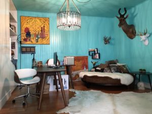 Cozy rustic bedroom with turquoise walls and animal-themed decor.