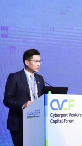 A man in a suit speaking at a conference podium with a CVCF logo.