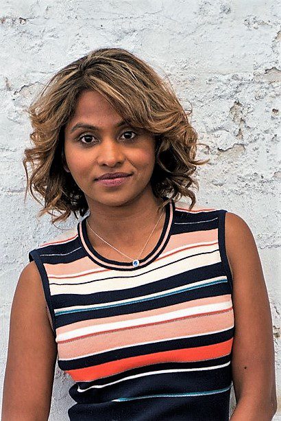 Young woman with curly hair wearing a striped sleeveless top.