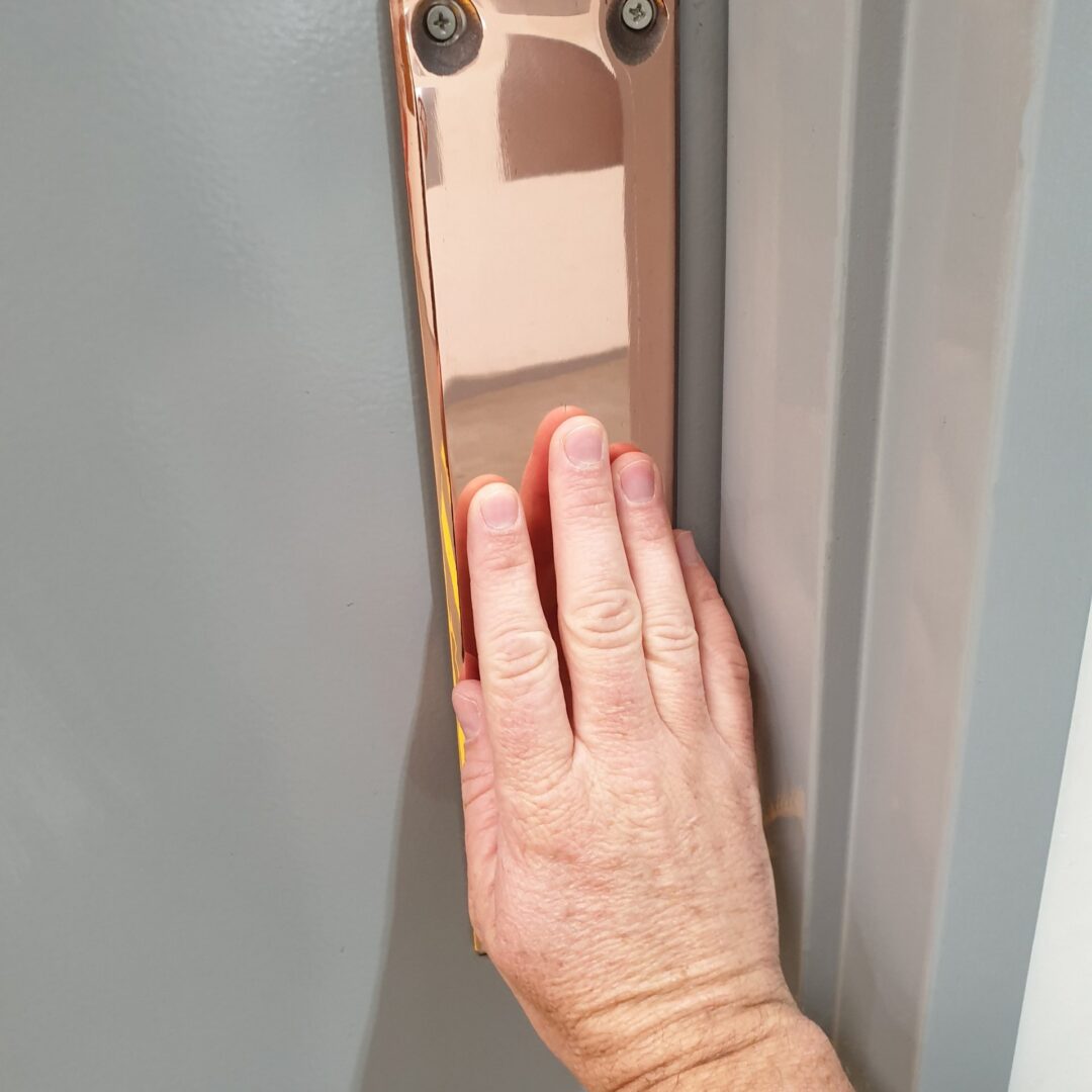Hand pressing an elevator button panel inside an elevator.