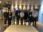 A group of seven people posing indoors in a professional setting.