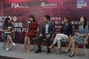 Panel discussion with four professionals on stage at a conference.