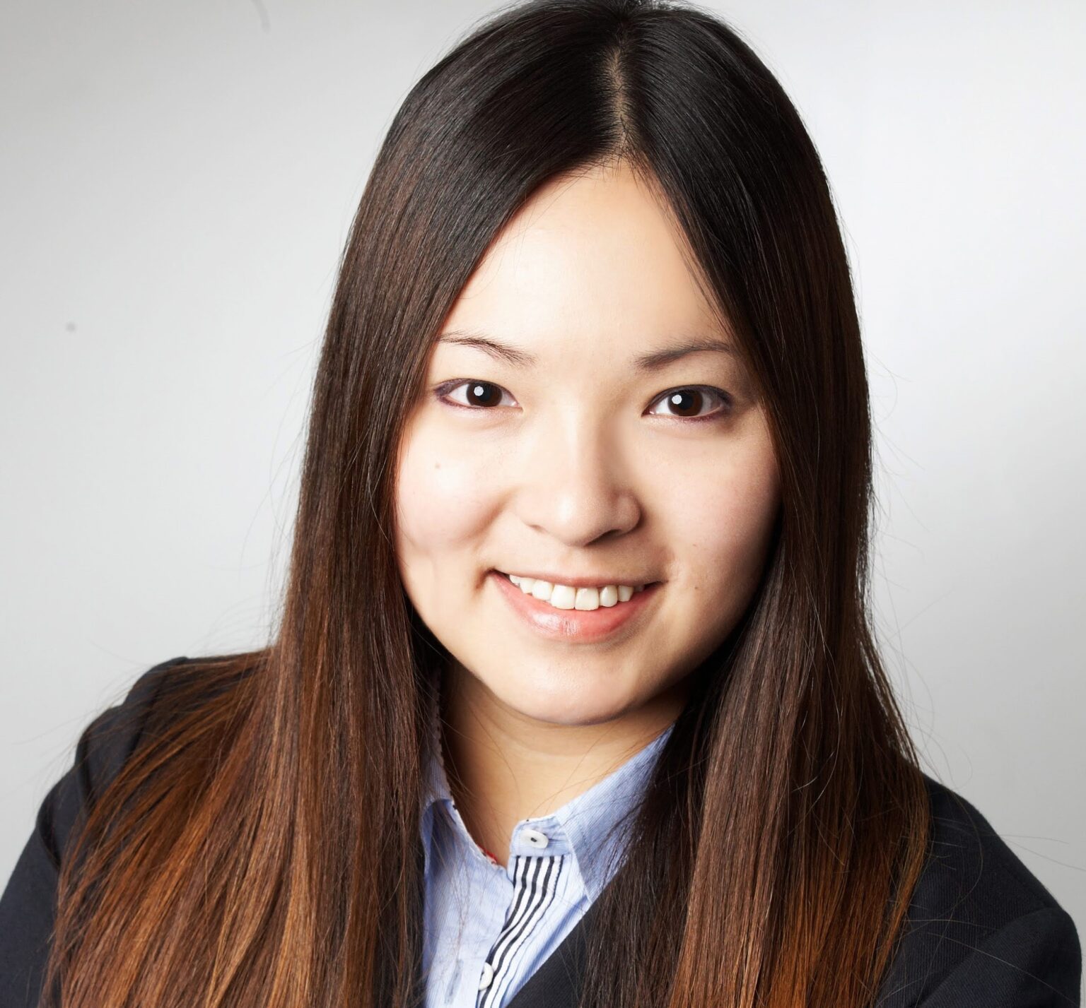 Professional headshot of a young woman with long dark hair, smiling.
