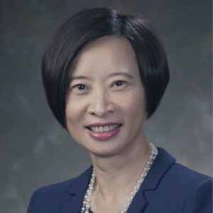 Professional portrait of a woman with short black hair and a navy blazer.