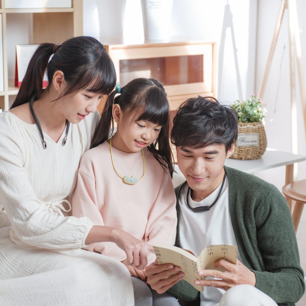 Family reading a book together at home.