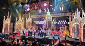 A vibrant stage show with performers and colorful lights.