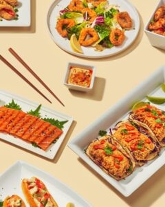 A vibrant spread of Asian dishes featuring sushi and tacos.