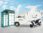 Electric delivery vehicle, scooter, and parcel lockers branded UOTTA under blue sky.