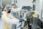 Two scientists in protective gear working with lab equipment in a cleanroom.