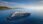 A large cruise ship sailing near a coastline under a clear sky.