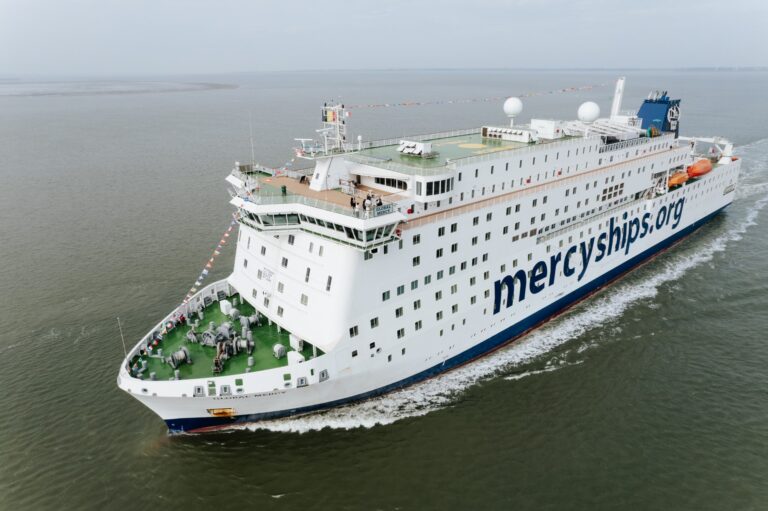 Large Mercy Ships vessel sailing on calm waters.