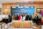 Group photo of business professionals at a contract signing ceremony.
