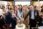 Group of people cutting a cake at a pet-themed event.